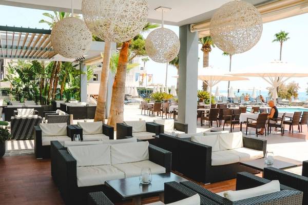 Loungebereich des Marins Playa Suites Hotels mit vielen Sofas und Tischen im Freien.