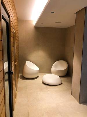 Innenbereich des Marins Playa Suites Hotels mit drei weißen Sesseln und einer Holzwand.