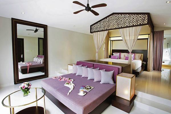 Schlafzimmer im TIA Wellness Resort mit einem großen Bett, Spiegel und Nachttischen.