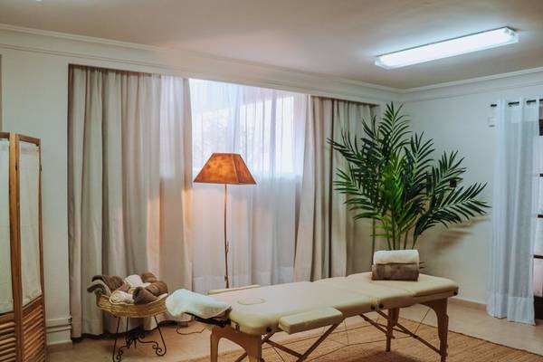 Massage-Behandlungsraum im Marins Playa Suites mit Therapiebett, Lampe und Pflanzen.