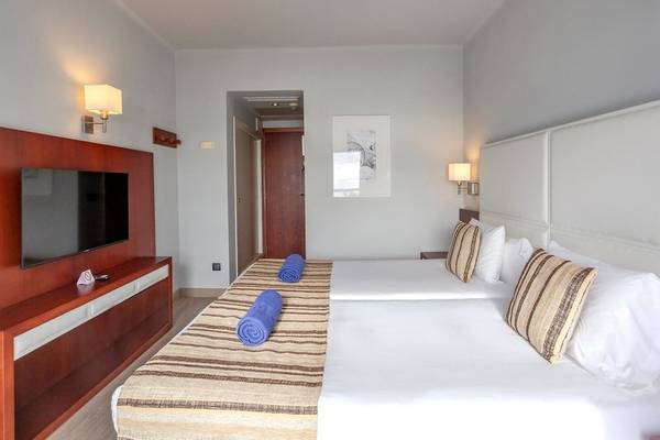 Hotelzimmer von Marins Playa Suites mit zwei Betten, Fernseher und Dekor.