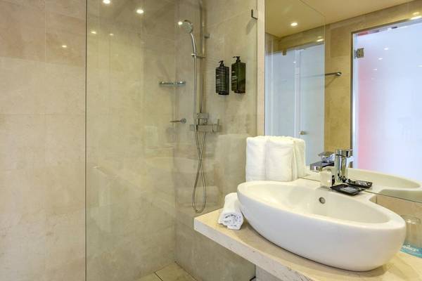 Badezimmer im Marins Playa Suites Hotel mit ebenerdiger Dusche und Waschbecken.