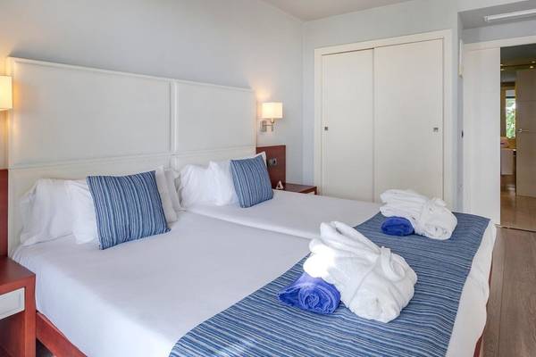 Doppelbett-Zimmer im Marins Playa Suites Hotel mit weißen Wänden und blauen Akzenten.