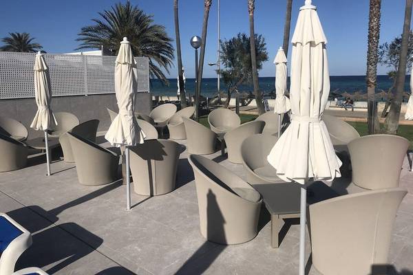 Terrasse des R2 Veronica Beach Hotel mit Stühlen und Sonnenschirmen am Meer