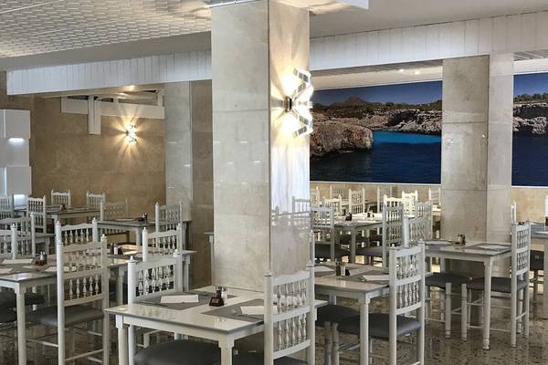 Innenbereich des Restaurants im R2 Veronica Beach Hotel mit weißen Tischen und Stühlen.