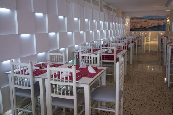 Innenansicht des Restaurants im R2 Veronica Strand Hotel mit geräumigen Tischen und Stühlen.