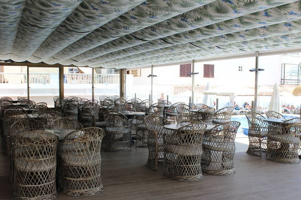 Innenbereich des R2 Veronica Beach Hotels mit Tisch und Stühlen.
