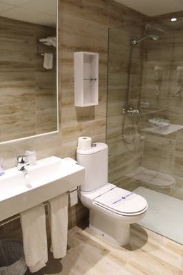 Badezimmer des R2 Veronica Beach Hotel mit einer Dusche, Toilette und Waschbecken.