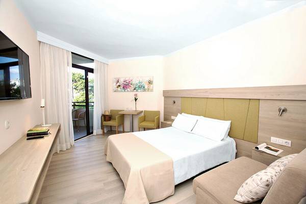 Ein modernes Hotelzimmer im Sabina Playa Hotel mit einem Bett, Fernseher, und Balkonzugang.