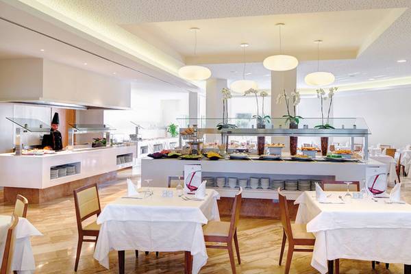 Restaurant im Hipotels Dunas Cala Millor mit Buffet und gedeckten Tischen.