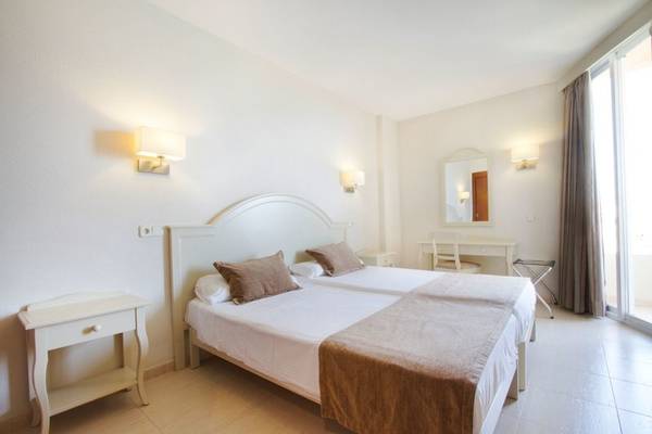 Doppelzimmer im Bakour Garbi Hotel in Cala Millor mit zwei Betten, Nachttischen und Schreibtisch.