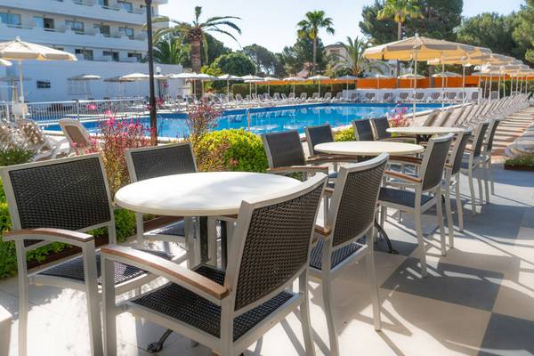 Außenterrasse des Hotels Millor Sol mit Tischen und Stühlen neben dem Pool