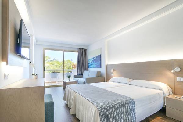 Ein modernes Hotelzimmer im Millor Sol mit zwei Betten, Fernseher, Couch und Balkon.