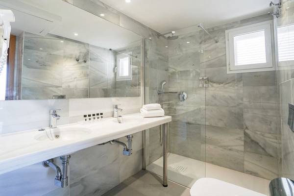 Badezimmer des Millor Sol Hotels mit Doppelwaschbecken, Dusche und Toilette