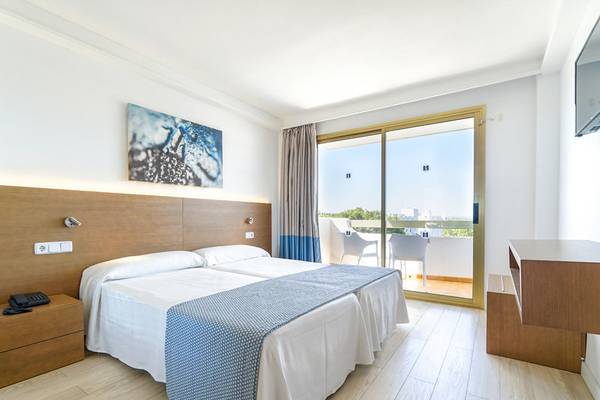 Ein modernes Hotelzimmer mit Doppelbett und Balkon, Blick auf die Stadt.