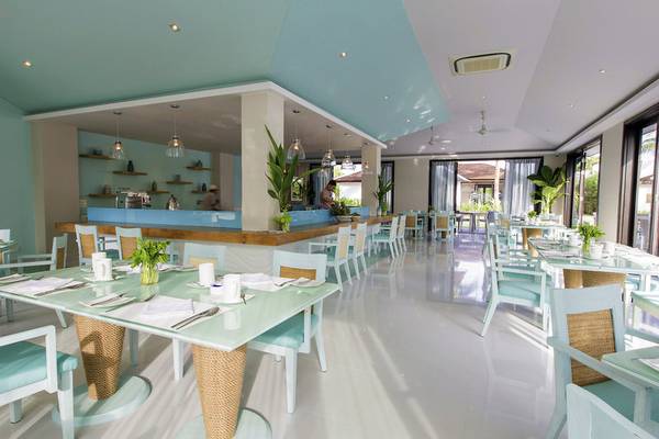 Innenansicht des Restaurants im TIA Wellness Resort mit blauen und weißen Möbeln.