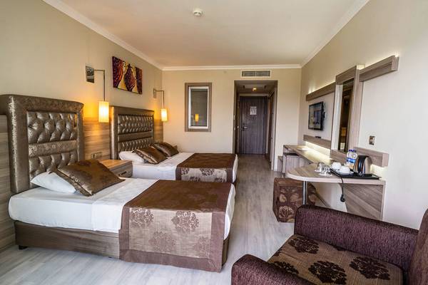 Doppelzimmer im Green Nature Diamond Hotel mit zwei Betten, einem Schreibtisch und einem Fernseher an der Wand.