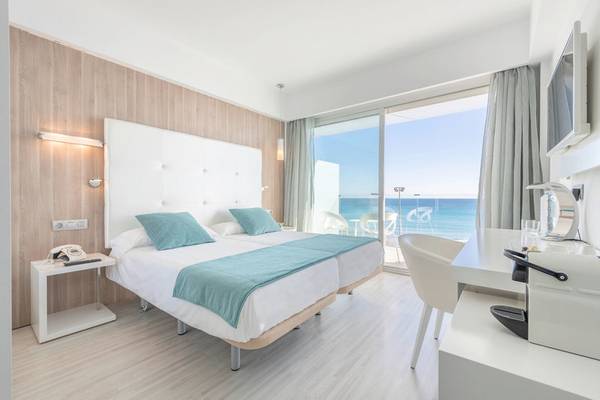Zimmer im Kyrat Amarac Hotel mit Meerblick, zwei Betten, Schreibtisch und moderner Einrichtung.