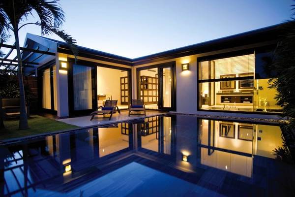 TIA Wellness Resort Villa bei Nacht mit Pool und Lounge-Sesseln