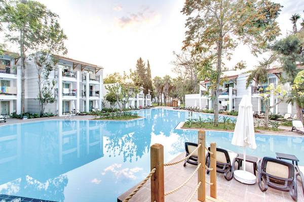 Außenpool des Sherwood Exclusive Kemer Hotels mit Liegestühlen und Sonnenschirmen.