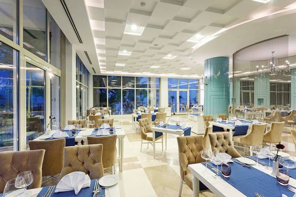 Innenansicht des Restaurants im Sherwood Exclusive Kemer Hotel mit geräumigen Tischen und Stühlen.