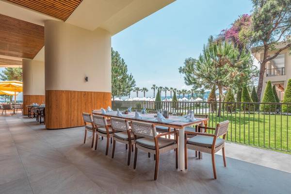 Sherwood Exclusive Kemer Hotel Terrasse mit Tisch und Stühlen.