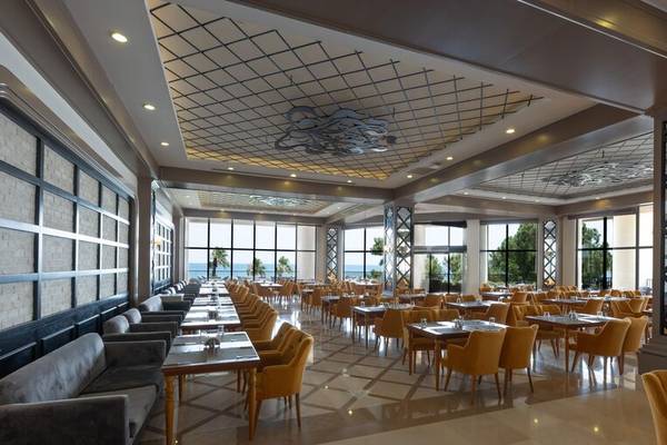 Innenansicht des Restaurants des Sherwood Exclusive Kemer Hotels mit vielen Tischen und Stühlen.