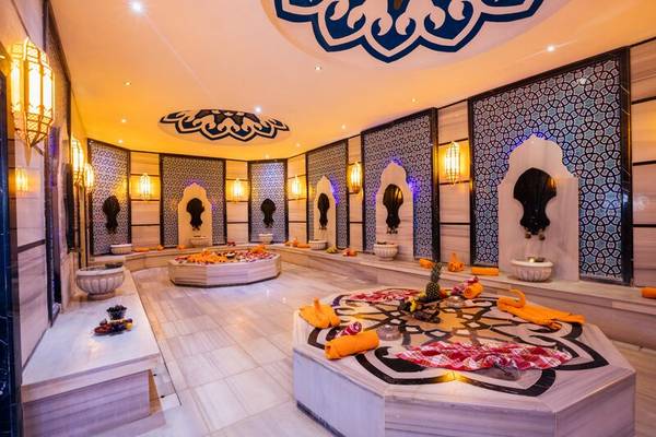 Innenbereich des Sherwood Exclusive Kemer Spa mit dekorativen Wandverkleidungen und beleuchteten Lampen.