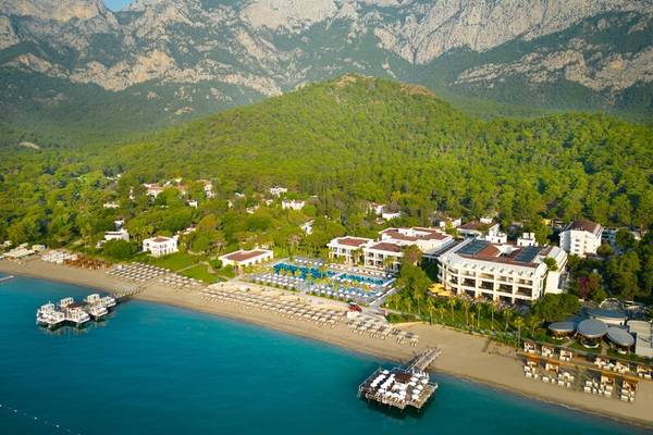 Luftaufnahme des Sherwood Exclusive Kemer Hotels mit Blick auf die Berge und den Strand