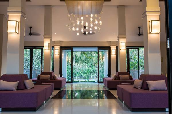 Lobby des TIA Wellness Resorts mit violetten Sofas, Glastüren und großen Fenstern