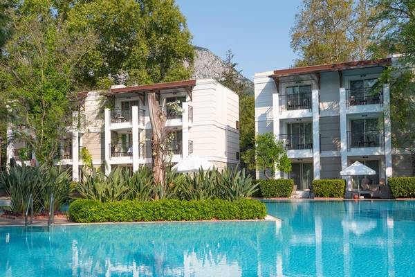 Außenansicht des Sherwood Exclusive Kemer Hotels mit Swimmingpool und Bäumen