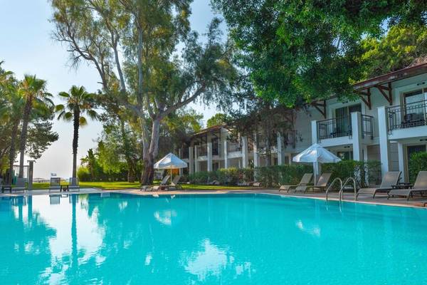 Außenbereich des Sherwood Exclusive Kemer Hotels mit Swimmingpool, Sonnenliegen und Schirmen.