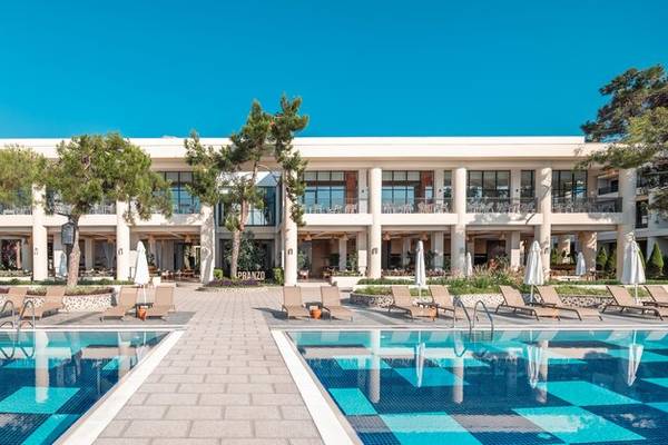 Außenpoolbereich des Sherwood Exclusive Kemer Hotels mit Loungestühlen und Sonnenschirmen.