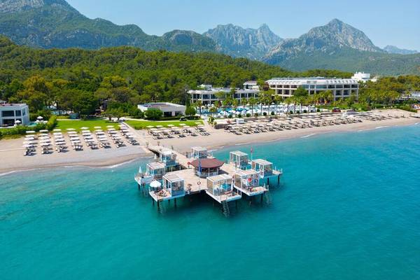 Luftbild des Sherwood Exclusive Kemer Hotels mit Blick auf den Strand, Pool und Berglandschaft