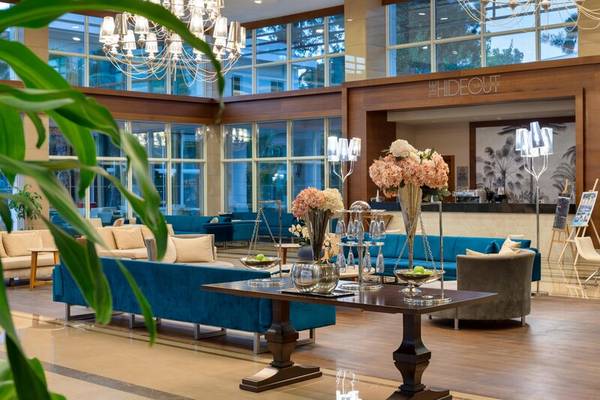 Lobby des Sherwood Exclusive Kemer Hotels mit blauen Sofas, einem Tisch und Pflanzen.