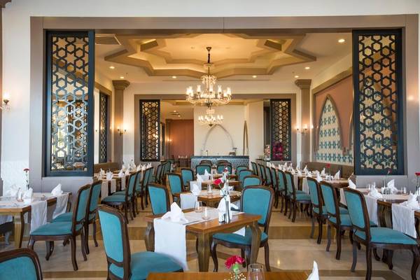 Innenansicht des Restaurants im Sherwood Exclusive Kemer Hotel mit blauen Stühlen und Tischen.