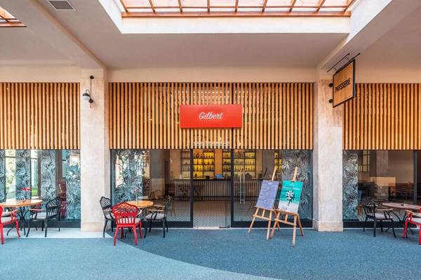 Außenansicht des Cafe Gilbert im Sherwood Exclusive Kemer Hotel mit roten Stühlen und Tischen.