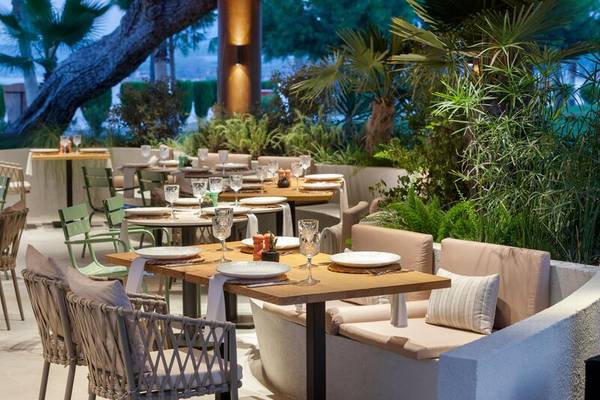 Gartenrestaurant des Sherwood Exclusive Kemer Hotels mit gedeckten Tischen und Stühlen