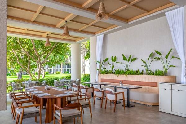 Terrassenrestaurant des Sherwood Exclusive Kemer Hotels mit Tischen, Stühlen und Pflanzen