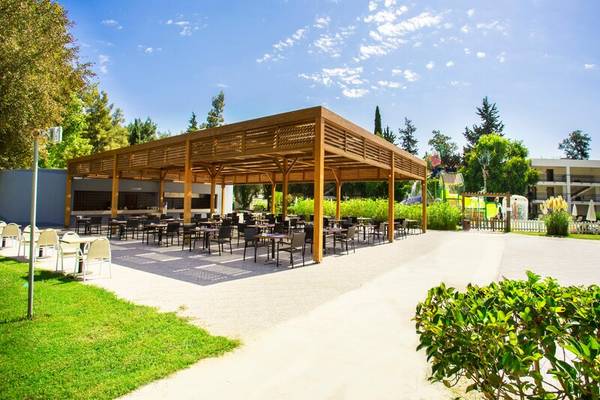 Outdoor-Restaurant des Sherwood Exclusive Kemer Hotels mit Holzdach und Tischen und Stühlen.