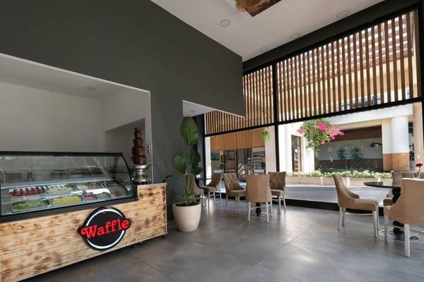 Innenansicht der Waffel Bar im Sherwood Exclusive Kemer Hotel mit einer Waffel Theke und freien Tischen