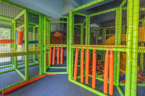 Kinderspielplatz im Sherwood Exclusive Kemer Hotel mit grünen und orangefarbenen Strukturen und Netzen.