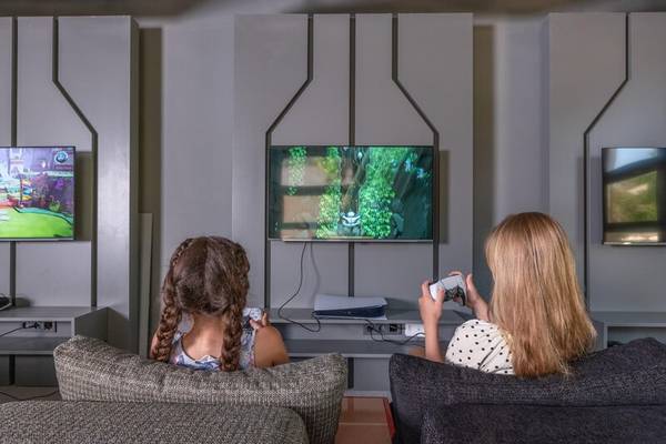 Zwei Kinder spielen Videospiele im Sherwood Exclusive Kemer Hotel.