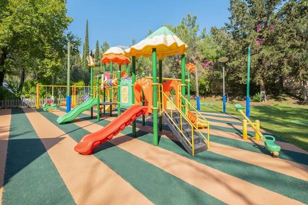 Kinderspielplatz im Sherwood Exclusive Kemer Hotel mit Rutschen und Spielgeräten.