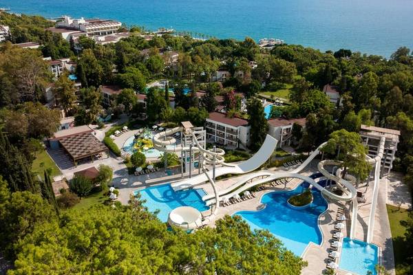 Luftaufnahme des Sherwood Exclusive Kemer Hotels mit Wasserpark und Meer im Hintergrund.
