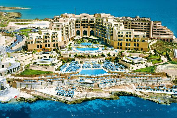 Luftaufnahme des Corinthia St. George's Bay Hotels mit Swimmingpools und Sonnenliegen