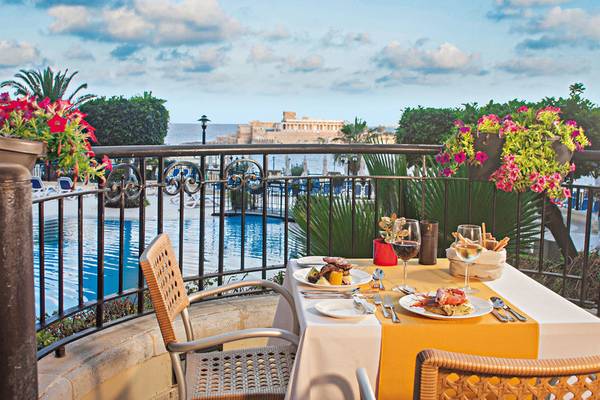 Terrasse im Corinthia St George's Bay Hotel mit Blick auf den Pool und das Meer
