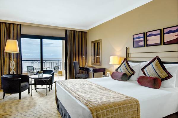 Corinthia St George's Bay Hotel Suite Zimmer mit Meerblick und komfortablen Möbeln.