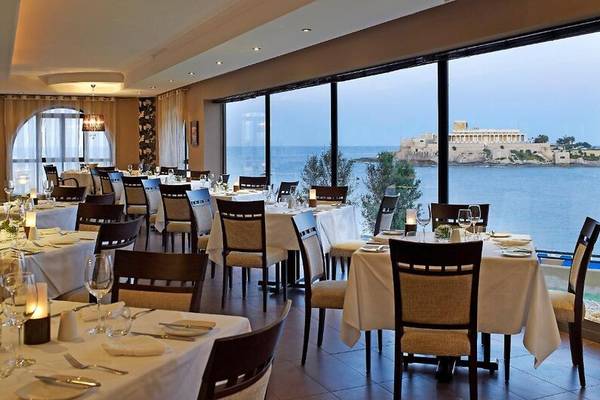 Restaurant im Corinthia St George's Bay mit Blick auf das Meer und die Küste.