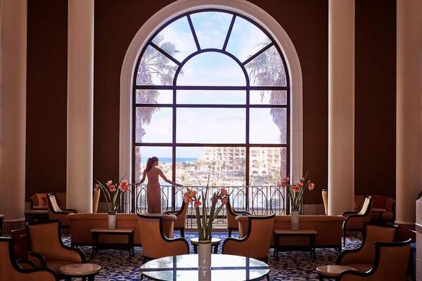Frau in der Lobby des Corinthia St. George's Bay mit Blick auf das Meer